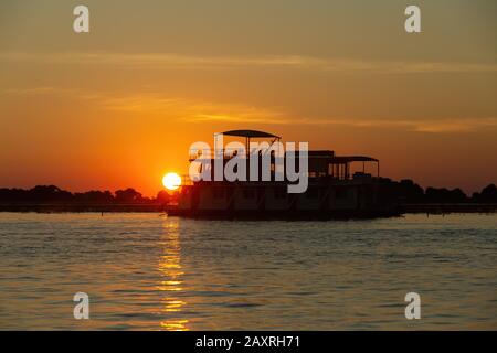 sunset over boat on Chobe river landscape, Botswana, Africa wilderness Stock Photo