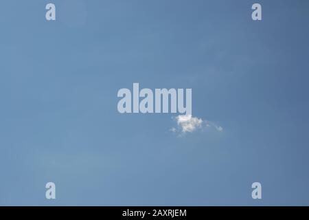 Beautiful blue sky with small white fluffy cloud, copy space, background Stock Photo
