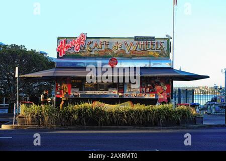 Harrys Cafe De Wheels famous pie cart caravan at Woolloomooloo, late afternoon, neon signs illuminated in rich colours, food in Sydney, Australia Stock Photo