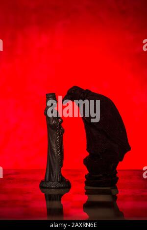 Сhess as an abstract concept. Two chess kings on red background. Stock Photo