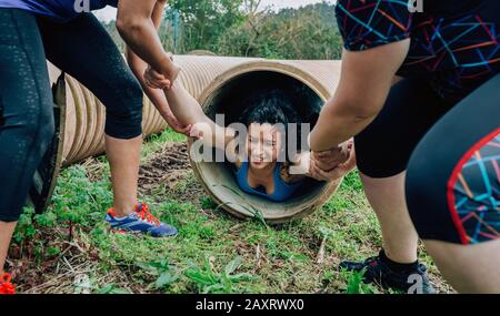 Participants obstacle course going through a pipe Stock Photo
