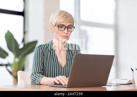 Serious Businesswoman Using Laptop Working In Modern Office Stock Photo