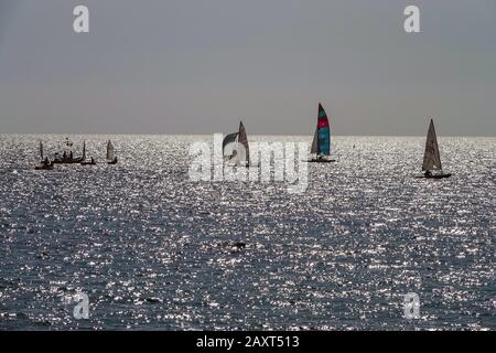 Small boats, yachts, sailing on a silver sea off the Spanish coast at Vilajoyosa, Costa Blanca, Spain Stock Photo