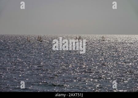 Small boats, yachts, sailing on a silver sea off the Spanish coast at Vilajoyosa, Costa Blanca, Spain Stock Photo