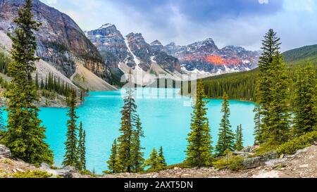 Panorama of Moraine Lake with nicely illuminaten mountains in the back, Alberta, Canada Stock Photo