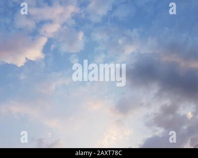 Blue sky with sunny white purple clouds Stock Photo