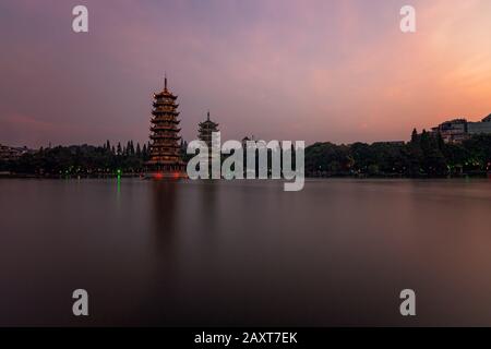 Sun and Moon Pagodas Towers at Shanhu or Shan Lake in Guilin town at sunset, Guangxi Province, China Stock Photo