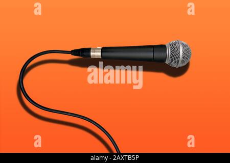 wired singer black and grey microphone on red lava color background Stock Photo