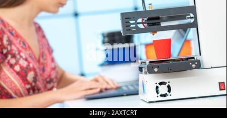 Young female designer works with a home 3D printer Stock Photo