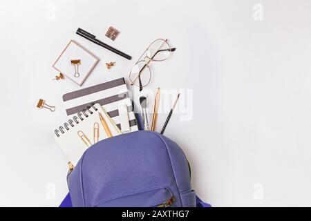 Backpack with different stationery and study supplies on the white background Stock Photo