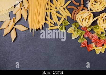 Different types of pasta on a black slate background Stock Photo