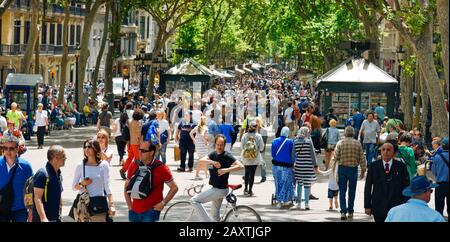 BARCELONA, SPAIN - MAY 22, 2017: People walking by the upper section of La Rambla in Barcelona, Spain. Thousands of people walk daily by this popular Stock Photo