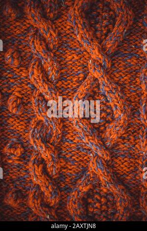 background knitted braids with red thread closeup Stock Photo