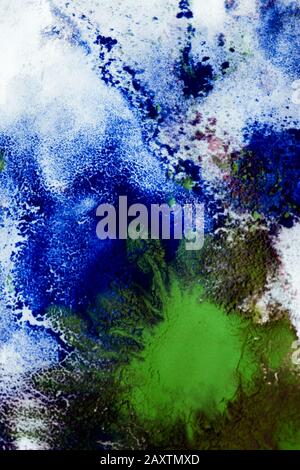 Mixing of paints of different colors on a white paper. Abstract colorful background, base Stock Photo