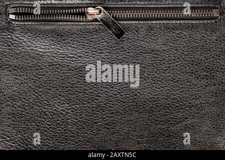 background texture black leather. Pocket of the bag with a lock, close-up, open half-lock zipper top, close up. Stock Photo