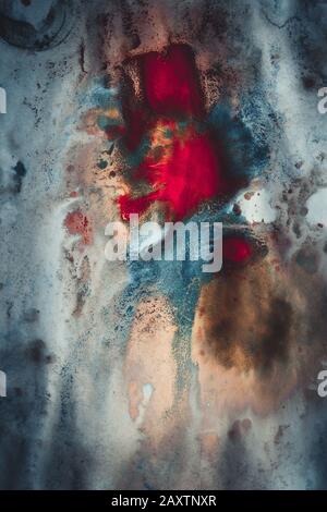 dark ink spots of different colors on a white wet paper Stock Photo