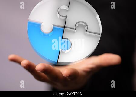 Circular object made of jigsaw puzzles over a person's fingers Stock Photo