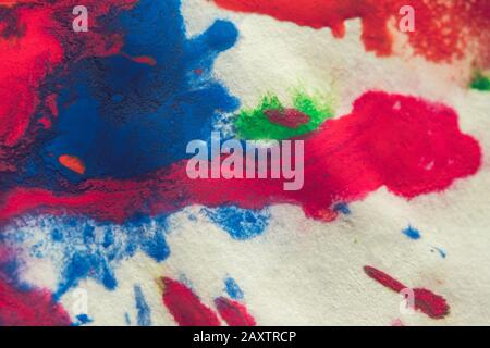 abstract spots splash of bright red, green, blue colors on white paper macro Stock Photo