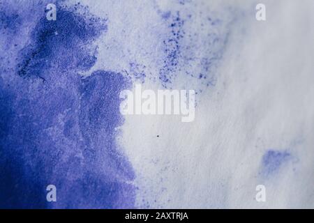 Purple ink stain on a sheet of white paper macro. Abstract background. Spreads ink stains with streaks on a white background Stock Photo
