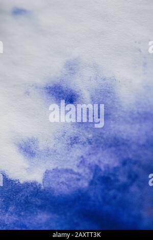 Purple ink stain on a sheet of white paper macro. Abstract background. Spreads ink stains with streaks on a white background Stock Photo