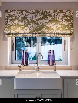 Kitchen sink with vases and Roman blinds Stock Photo