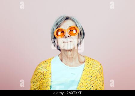 happy elderly grandma portrait with orange sunglasses - forever young lifestyles Stock Photo