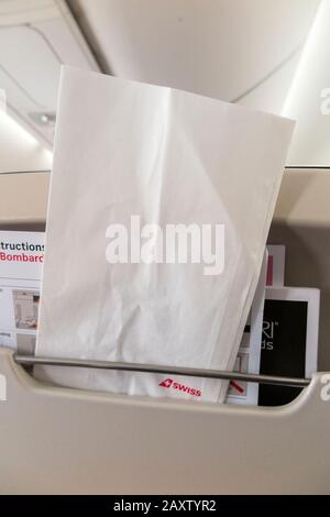 Sick / travel motion sickness bag for safe collection / holding of vomit if someone is ill, in the back of a plane seat during an airplane flight. (112) Stock Photo