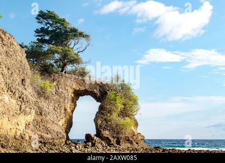 Geological formation of Rock Arch at Neil island, looks like natural bridge or a natural gate, formed off constant erosion; with calm sea and blue sky Stock Photo