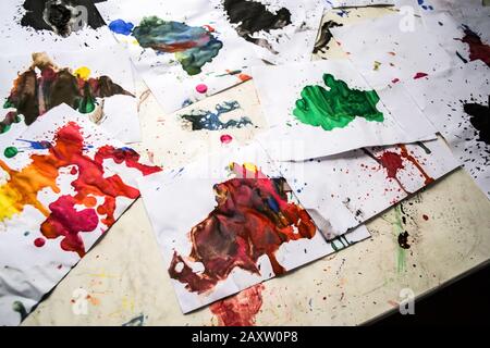 Many red colored blots on white paper with streaks. Abstract creative spots of paint on a white background. Red bright colors. Stained-spattered table Stock Photo