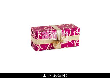 packaged rectangular gift in dark pink packaging with gold bow and gold pattern on a white background Stock Photo