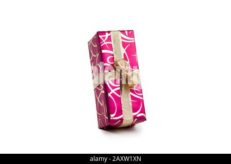 packaged rectangular gift in dark pink packaging with gold bow and gold pattern on a white background Stock Photo