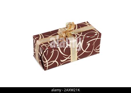packaged rectangular gift in dark brown packaging with gold bow and gold pattern on a white background Stock Photo