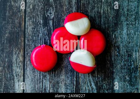 Babybel Cheese in Red Wex on Wooden Surface Ready to Eat. Instant Food. Stock Photo
