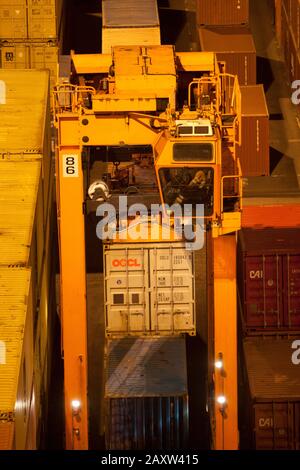 Container movers moving containers around port terminal for loading on and off ship. Stock Photo