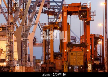 Container movers moving containers around port terminal for loading on and off ship. Stock Photo