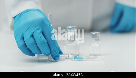 Hand putting syringe on table Stock Photo