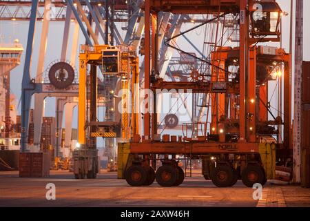 Container movers moving containers around port terminal for loading on and off ship. Stock Photo