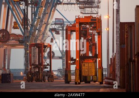 Container movers moving containers around port terminal for loading on and off ship. Stock Photo