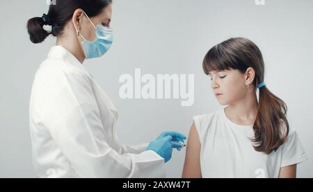 Doctor vaccinating young girl Stock Photo