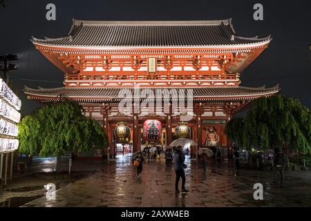 Japan, Tokyo: Senso-ji Temple in the district of Asakusa. Entrance to the temple and giant lantern suspended from the Kaminarimon gate, viewed at nigh Stock Photo