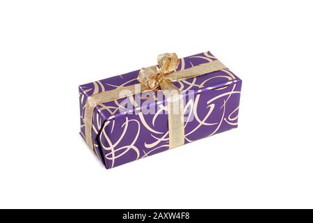 packaged rectangular gift in purple packaging with gold bow and gold pattern on a white background Stock Photo