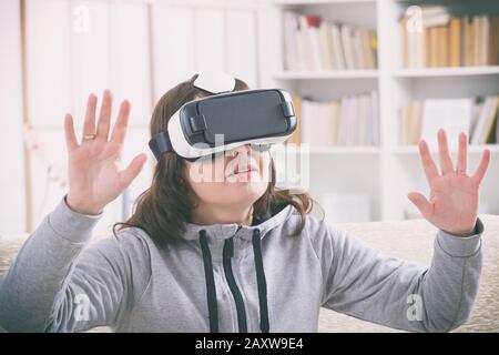 Woman using virtual reality headset at home Stock Photo