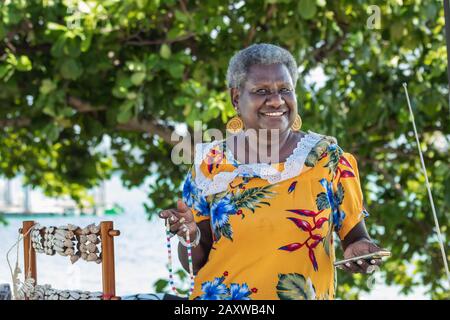 Portrait of a melanesian - australian artisan mature woman smiling, outdoors. Stock Photo