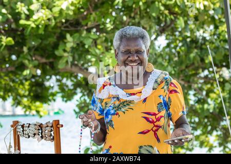 Portrait of a melanesian - australian artisan mature woman smiling, outdoors. Stock Photo