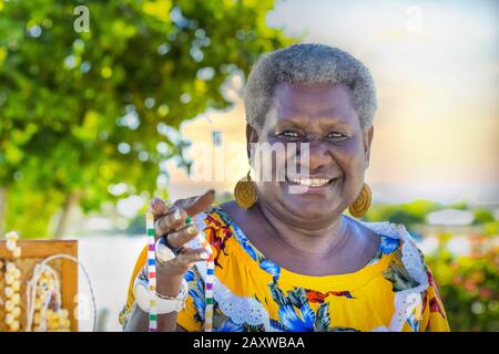 Portrait of a melanesian - australian mature woman smiling, outdoors. Stock Photo