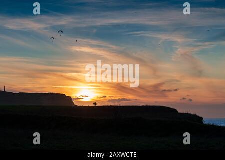 Parapentistes et randonneurs au coucher de soleil, France, Hauts de France, Cap Blanc-nez Stock Photo