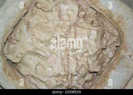 Wet white clay closeup. Abstract pieces of wet clay on the table close-up. Stock Photo