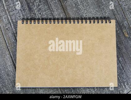 Background for different subjects with copy space for text: View on brown cover of ring file book on wood table Stock Photo