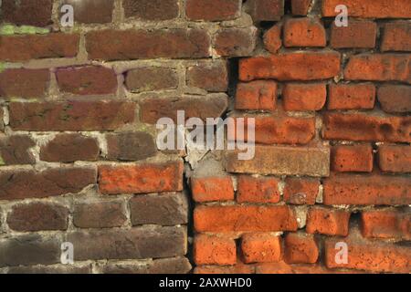 Red old worn brick wall texture background. Cracked brick wall. Two differnt colored bricks. Stock Photo