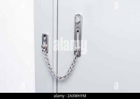 Security chain on the front door of the house. Fear and security concept Stock Photo